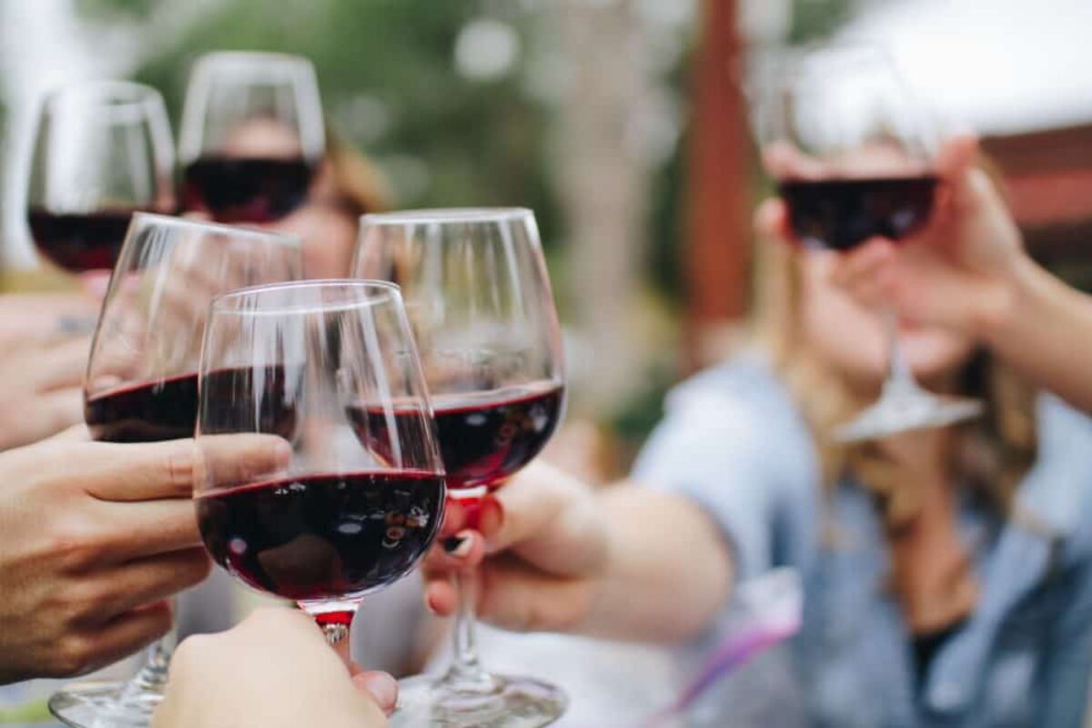 A glass of red wine on a rustic table, perfect for pairing with Papa Kee Wee Parmigiano Reggiano crisps